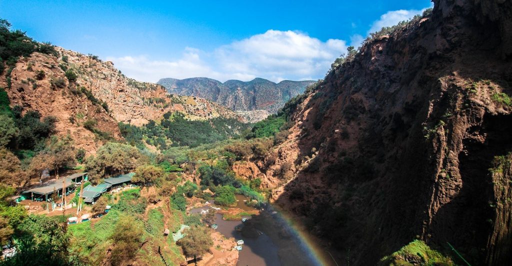 Splendido paesaggio di canyon con fiume e arcobaleno sotto un cielo azzurro limpido, perfetto per le foto di viaggio estive.