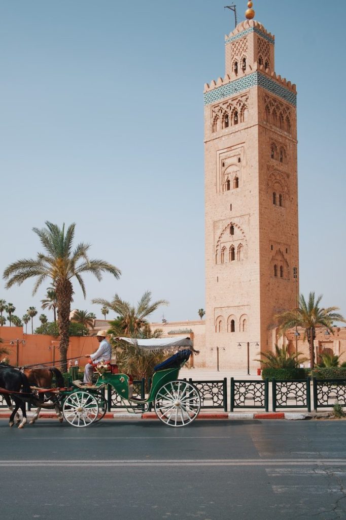 una carrozza trainata da cavalli davanti a un'alta torre