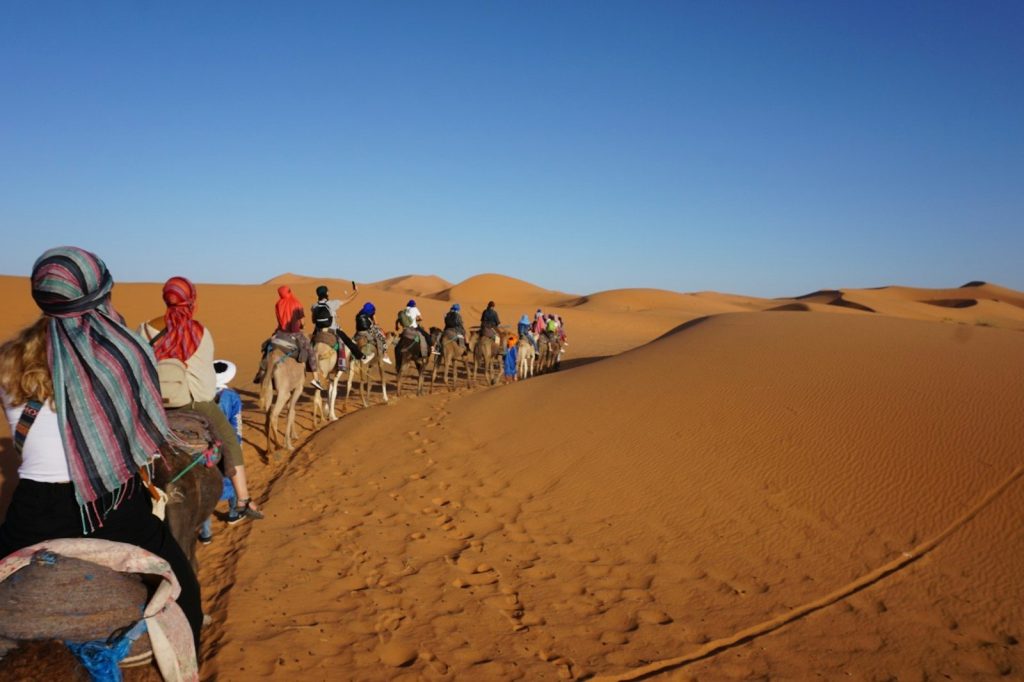 persone che camminano nel deserto durante il giorno