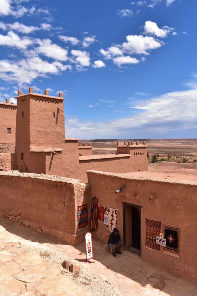 Una persona seduta su un muro con Tiwanaku sullo sfondo.